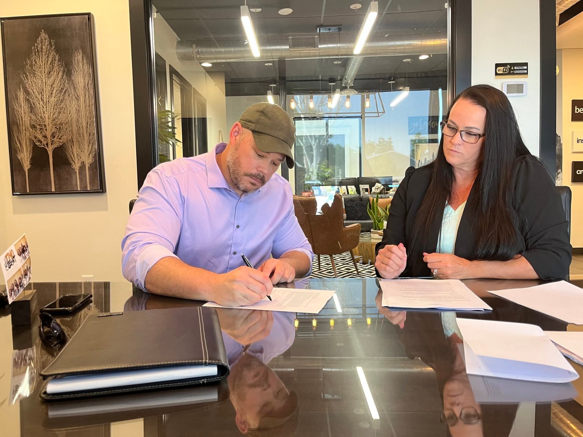 Andrew Hasser signing a master lease agreement at a closing table